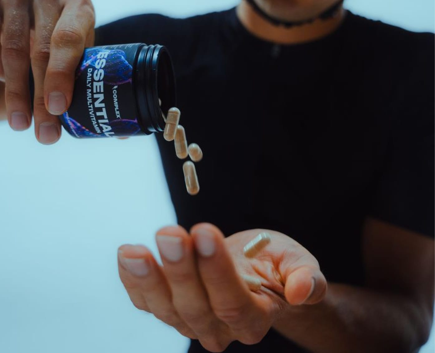 Complex Essentials capsules poured into an open hand